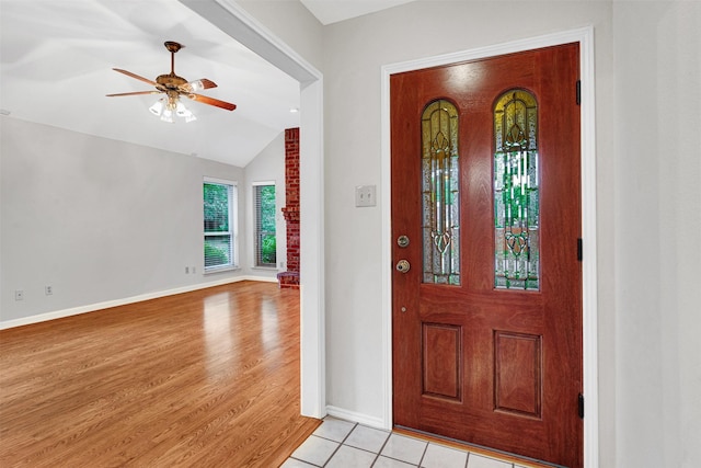 foyer entrance featuring light wood-type flooring, baseboards, ceiling fan, and vaulted ceiling