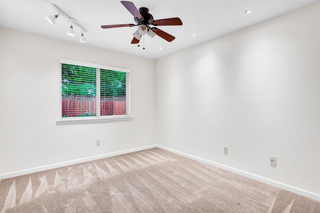 empty room featuring carpet, track lighting, recessed lighting, ceiling fan, and baseboards