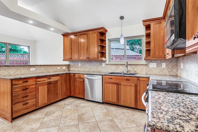kitchen with a peninsula, a sink, open shelves, brown cabinetry, and appliances with stainless steel finishes
