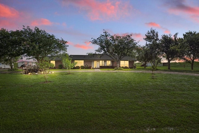 ranch-style home with a lawn