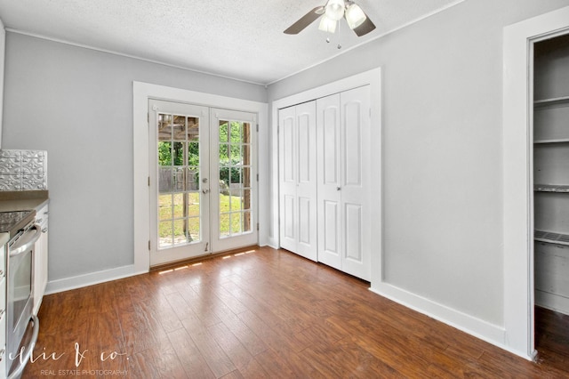 741 Vine St, Abilene, TX 79602 - unfurnished bedroom with dark wood-type flooring, baseboards, access to outside, a ceiling fan, and a textured ceiling