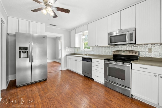 741 Vine St, Abilene, TX 79602 - kitchen featuring appliances with stainless steel finishes, tasteful backsplash, dark wood-type flooring, white cabinets, and a ceiling fan