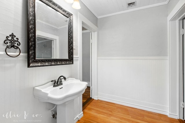 741 Vine St, Abilene, TX 79602 - bathroom featuring wood finished floors, a wainscoted wall, crown molding, and a sink