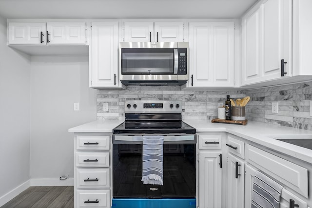 kitchen featuring dark wood finished floors, baseboards, light countertops, appliances with stainless steel finishes, and tasteful backsplash