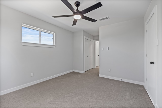 unfurnished bedroom featuring baseboards, a ceiling fan, visible vents, and carpet floors