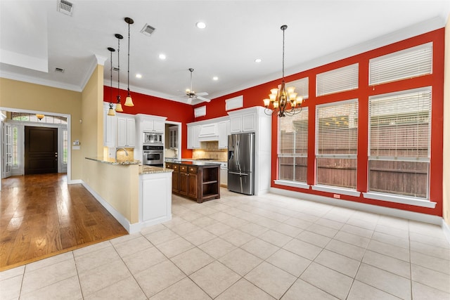 kitchen featuring backsplash, visible vents, appliances with stainless steel finishes, and ceiling fan with notable chandelier
