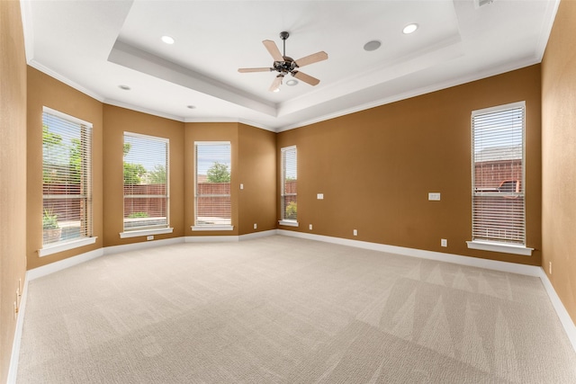 spare room with light colored carpet, recessed lighting, crown molding, ceiling fan, and a raised ceiling