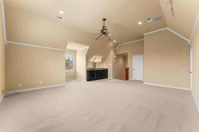 unfurnished living room featuring visible vents, vaulted ceiling, carpet floors, a ceiling fan, and baseboards