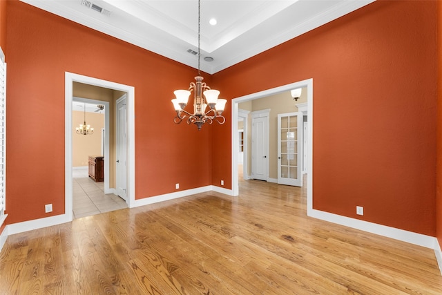 unfurnished dining area with a notable chandelier, baseboards, light wood finished floors, visible vents, and crown molding