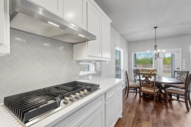 2506 Chalmers Rd, Glenn Heights, TX 75154 - kitchen with under cabinet range hood, stainless steel gas stovetop, backsplash, light countertops, and a chandelier