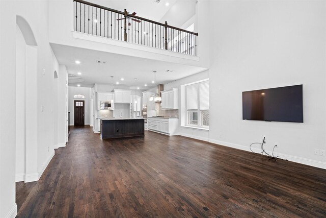 2507 Lavaca Dr, Euless, TX 76039 - unfurnished living room featuring dark wood-type flooring, a towering ceiling, baseboards, and recessed lighting