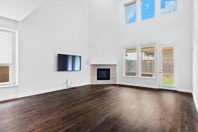 2507 Lavaca Dr, Euless, TX 76039 - unfurnished living room with dark wood finished floors, a high ceiling, a fireplace, and baseboards