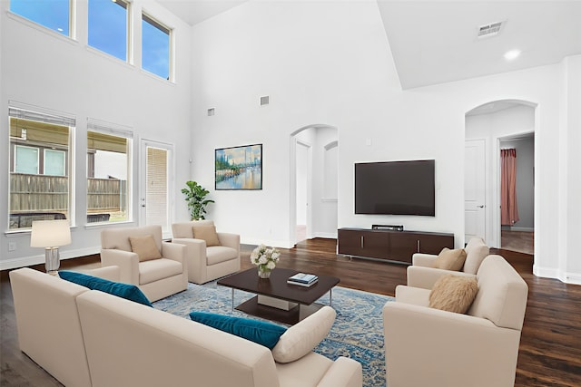 2507 Lavaca Dr, Euless, TX 76039 - living area with arched walkways, baseboards, wood finished floors, and a towering ceiling