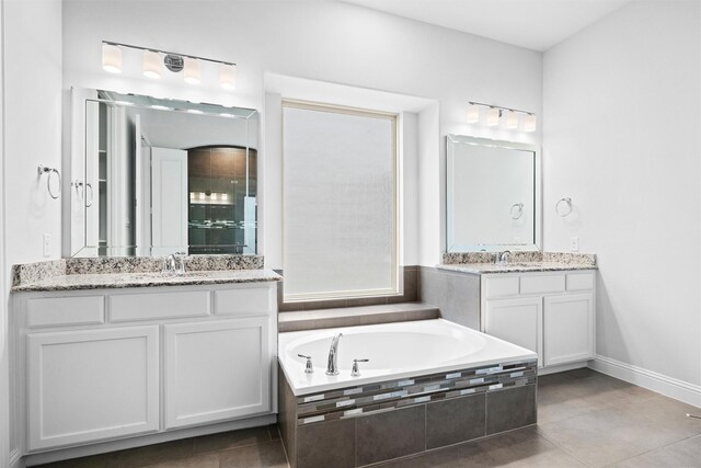 2507 Lavaca Dr, Euless, TX 76039 - full bath featuring two vanities, a garden tub, tile patterned flooring, tiled shower, and baseboards