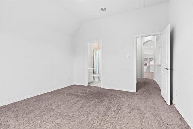 2507 Lavaca Dr, Euless, TX 76039 - unfurnished bedroom with carpet flooring, arched walkways, lofted ceiling, baseboards, and connected bathroom