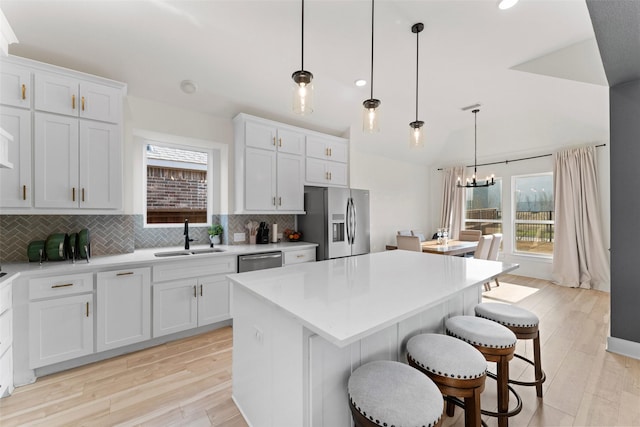 kitchen featuring a sink, an inviting chandelier, stainless steel appliances, and a wealth of natural light