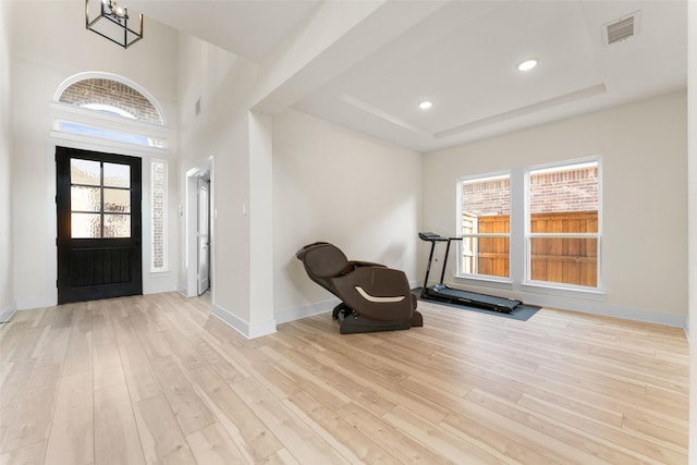 foyer featuring a wealth of natural light, visible vents, wood finished floors, and baseboards