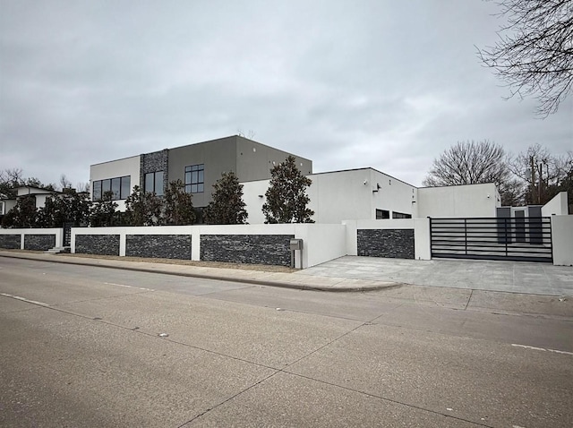 6218 Walnut Hill Ln, Dallas, TX 75230 - view of property exterior featuring a gate, fence, and stucco siding