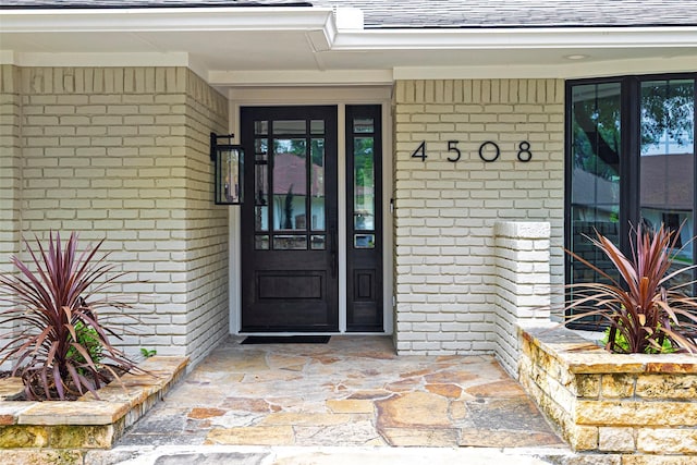 4508 Thunder Rd, Dallas, TX 75244 - property entrance featuring brick siding, roof with shingles, and covered porch