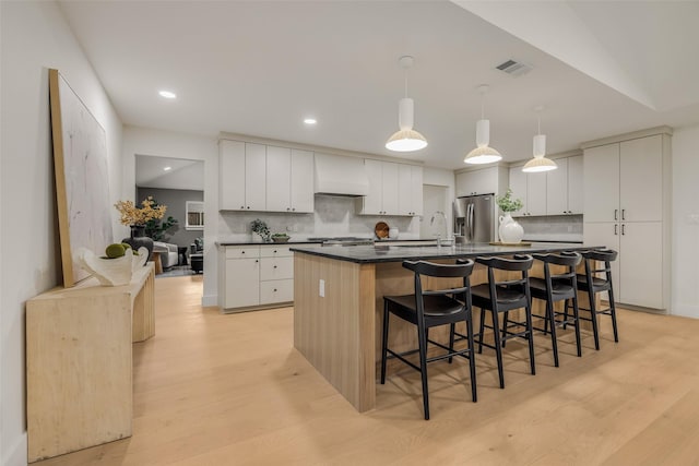 4508 Thunder Rd, Dallas, TX 75244 - kitchen with premium range hood, dark countertops, light wood-type flooring, decorative backsplash, and recessed lighting