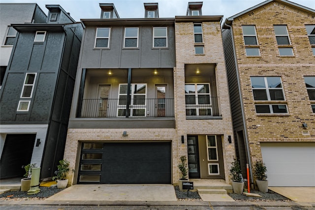 townhome / multi-family property with concrete driveway, a garage, and brick siding