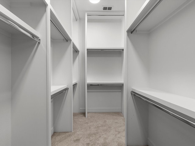 walk in closet with light carpet and visible vents