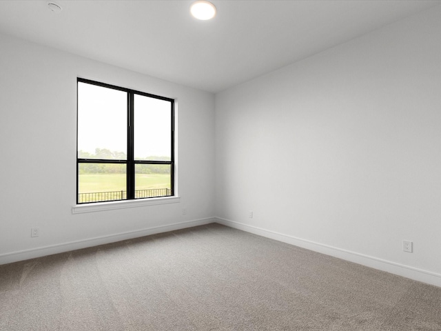 carpeted spare room with baseboards