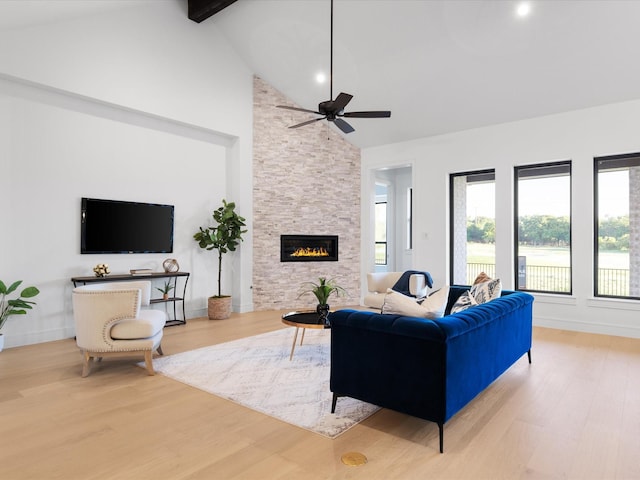 living room featuring wood finished floors, high vaulted ceiling, a fireplace, beamed ceiling, and ceiling fan