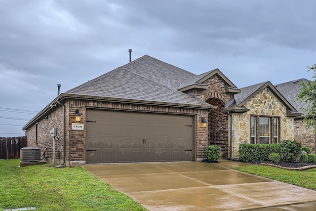 2828 Ainsworth Rd, Aubrey, TX 76227 - french provincial home featuring a garage, cooling unit, brick siding, roof with shingles, and concrete driveway