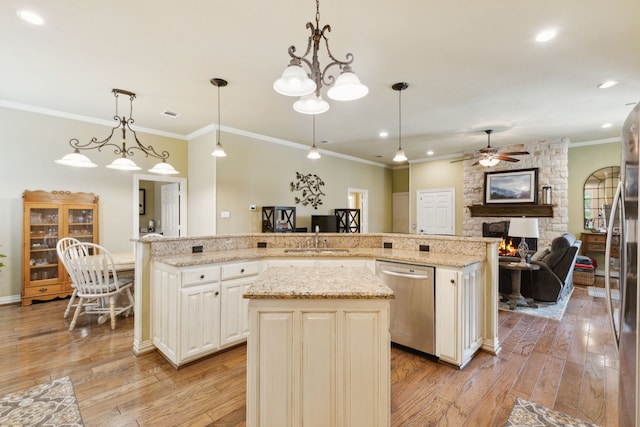 308 Dunlin Ln, Coppell, TX 75019 - kitchen featuring a stone fireplace, a sink, crown molding, a kitchen island, and stainless steel appliances