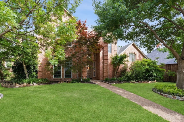 308 Dunlin Ln, Coppell, TX 75019 - view of front facade with a front lawn, brick siding, and fence
