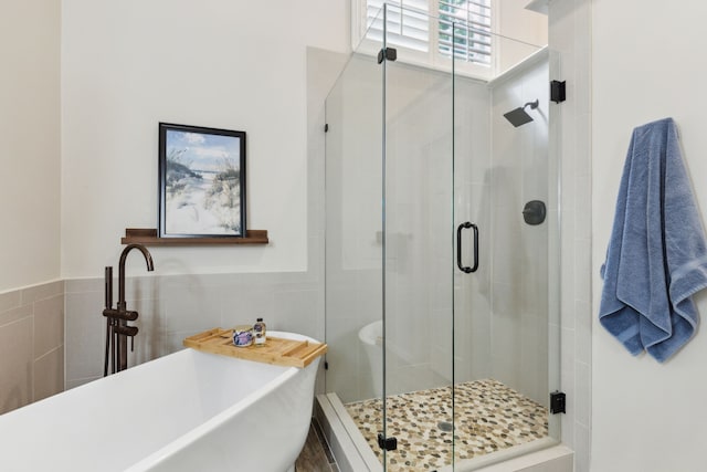 308 Dunlin Ln, Coppell, TX 75019 - full bathroom with a stall shower, tile walls, a freestanding tub, and a wainscoted wall