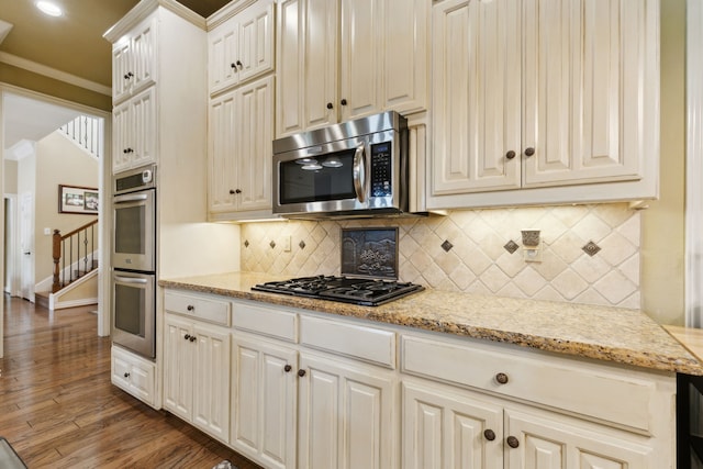 308 Dunlin Ln, Coppell, TX 75019 - kitchen with crown molding, stainless steel appliances, decorative backsplash, and wood finished floors