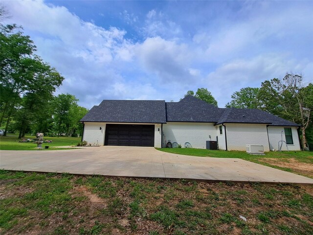 12890 County Road 463, Tyler, TX 75706 - view of front of home with cooling unit, a front lawn, a garage, driveway, and brick siding