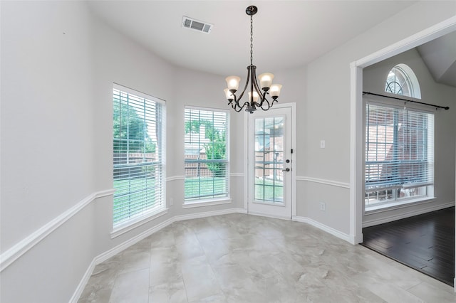 unfurnished dining area featuring a healthy amount of sunlight, a chandelier, baseboards, and visible vents