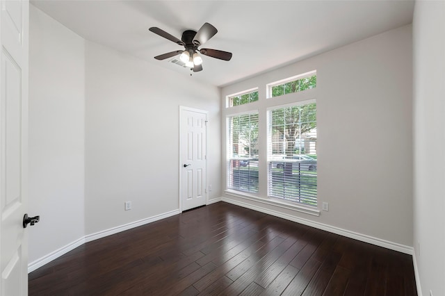 unfurnished room with dark wood finished floors, visible vents, baseboards, and a ceiling fan