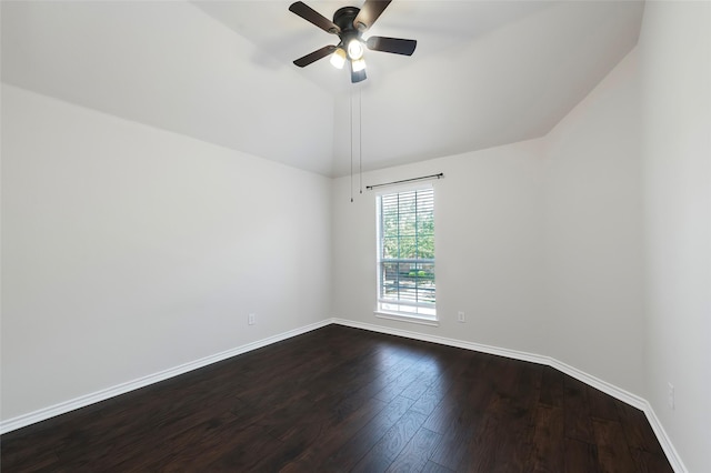 spare room featuring a ceiling fan, dark wood-style flooring, baseboards, and vaulted ceiling