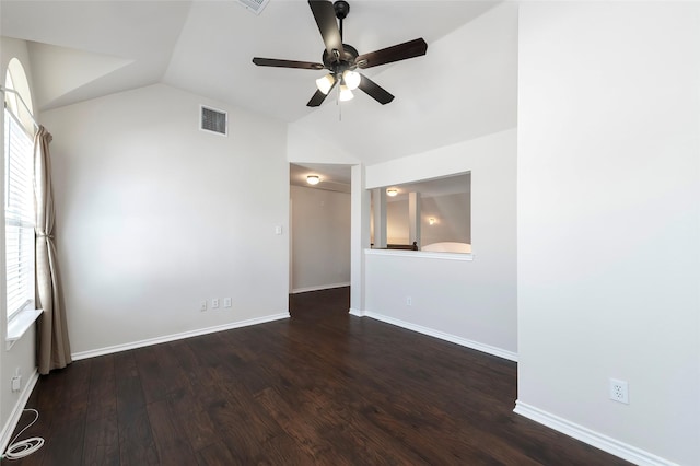 empty room with lofted ceiling, a ceiling fan, visible vents, and wood finished floors