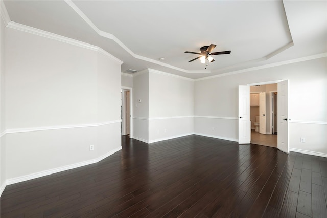 spare room with dark wood-style flooring, a raised ceiling, baseboards, and a ceiling fan