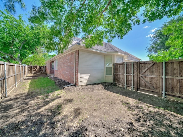 2035 Greenfield Ln, Allen, TX 75013 - back of property featuring brick siding, a fenced backyard, and a gate