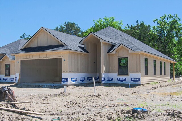 view of front of home featuring board and batten siding, a shingled roof, and an attached garage
