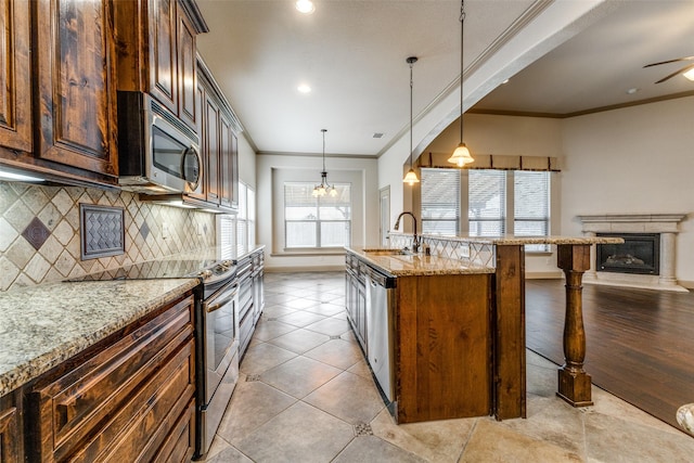 503 Olive Trl, Forney, TX 75126 - kitchen with stainless steel appliances, a kitchen bar, a sink, decorative backsplash, and light stone countertops
