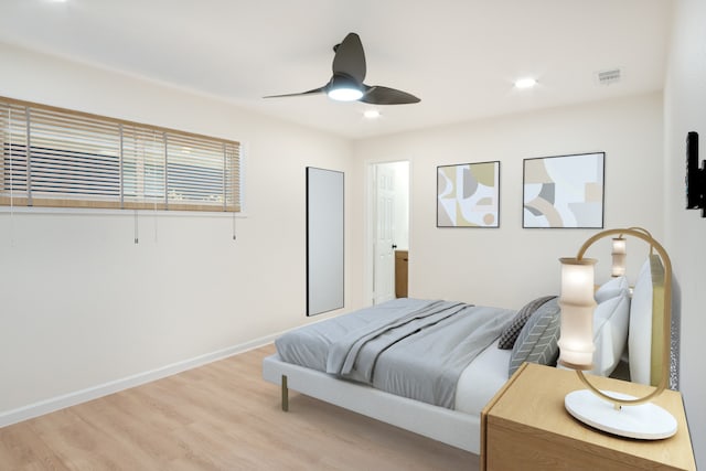 bedroom featuring a ceiling fan, baseboards, visible vents, and wood finished floors