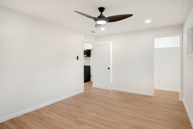 spare room with a ceiling fan, baseboards, and light wood-style flooring