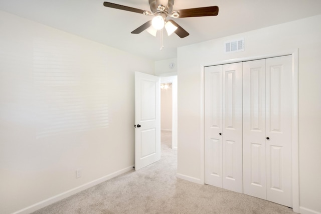 unfurnished bedroom featuring a closet, visible vents, ceiling fan, light carpet, and baseboards