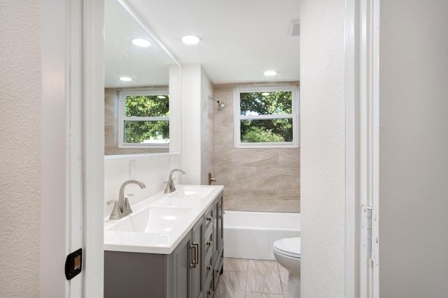 bathroom with a sink, toilet, and a wealth of natural light