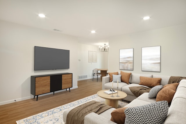 living area with a chandelier, visible vents, wood finished floors, and baseboards