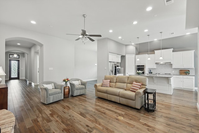 9800 Pikes Peak Pl, Oak Point, TX 75068 - living area with light wood finished floors, recessed lighting, a ceiling fan, baseboards, and arched walkways
