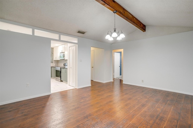 interior space featuring an inviting chandelier, visible vents, vaulted ceiling with beams, and wood finished floors
