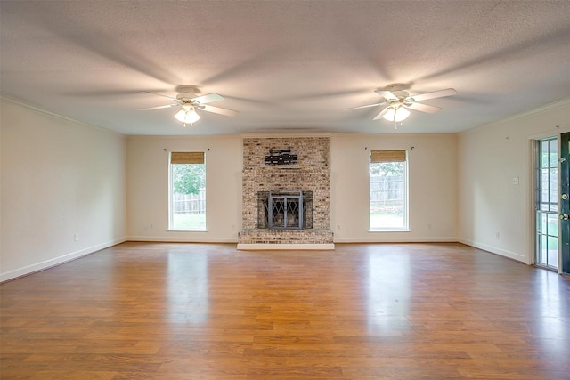 unfurnished living room featuring plenty of natural light, wood finished floors, and ceiling fan
